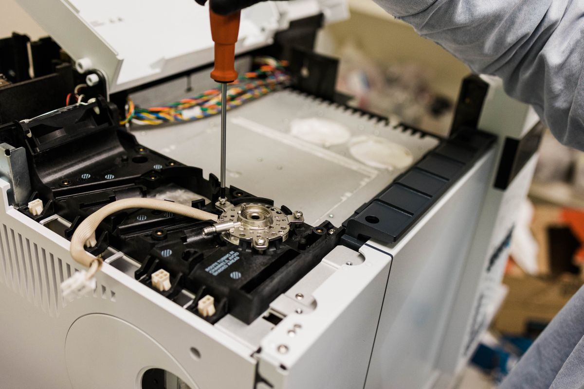 A man fixing and refurbishing an Agilent GC.