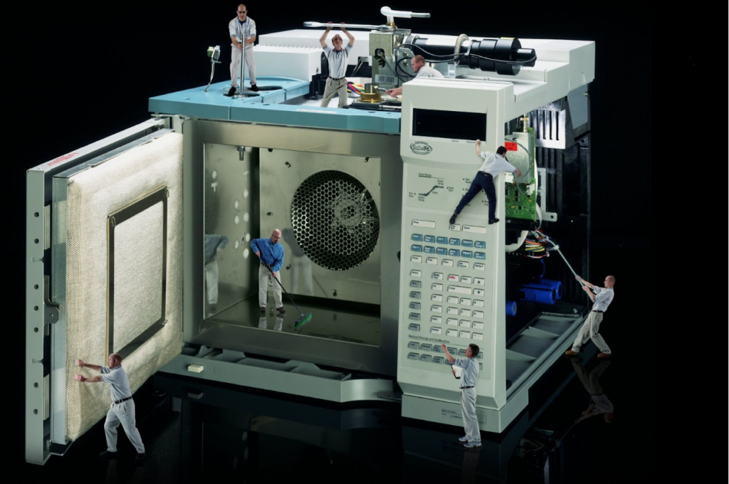 A lab instrument being cleaned by tiny people.